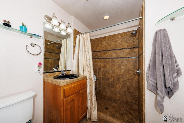 bathroom with a shower with curtain, toilet, a textured ceiling, and vanity