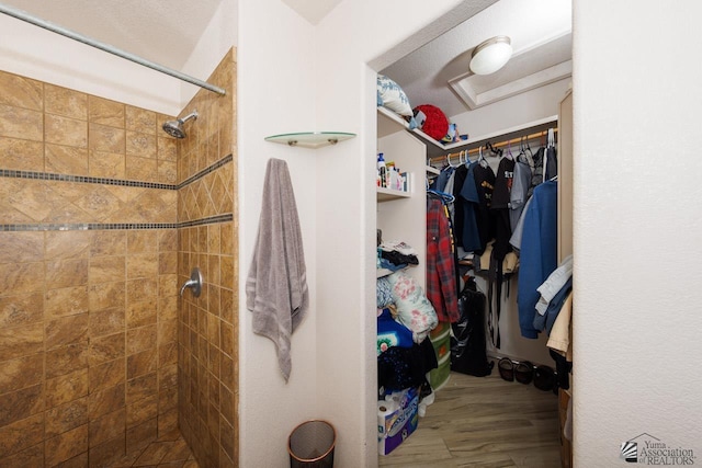 bathroom featuring a tile shower and hardwood / wood-style floors