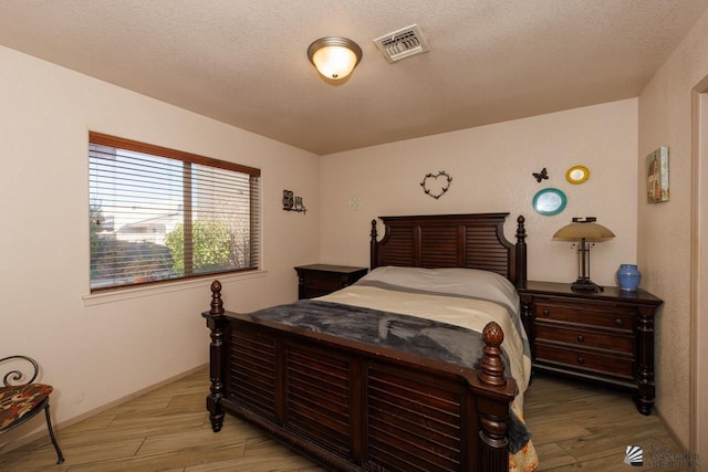 bedroom with hardwood / wood-style floors and a textured ceiling