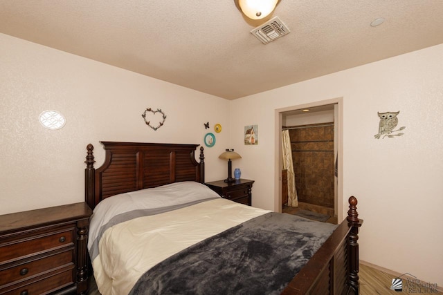 bedroom with a textured ceiling and ensuite bathroom