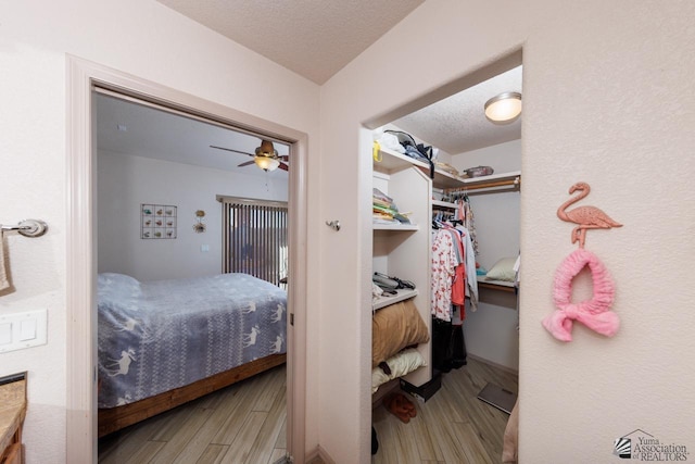 bedroom featuring ceiling fan, a textured ceiling, and hardwood / wood-style flooring