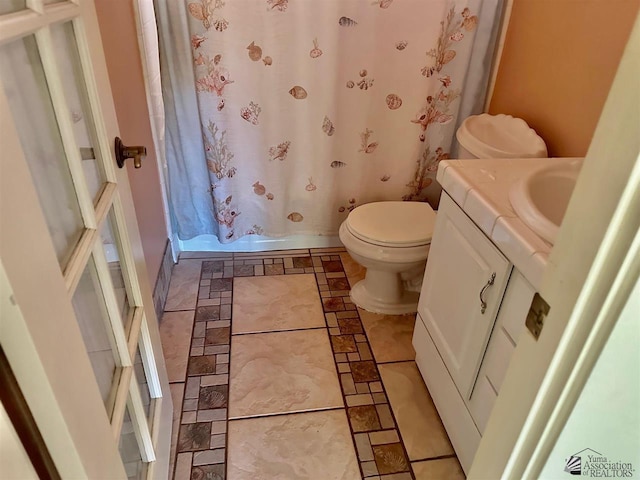 bathroom with toilet, walk in shower, and vanity