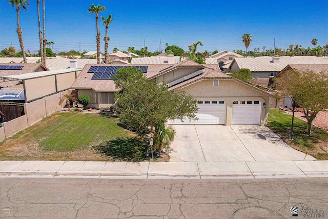 view of front of home featuring a front yard, solar panels, and a garage