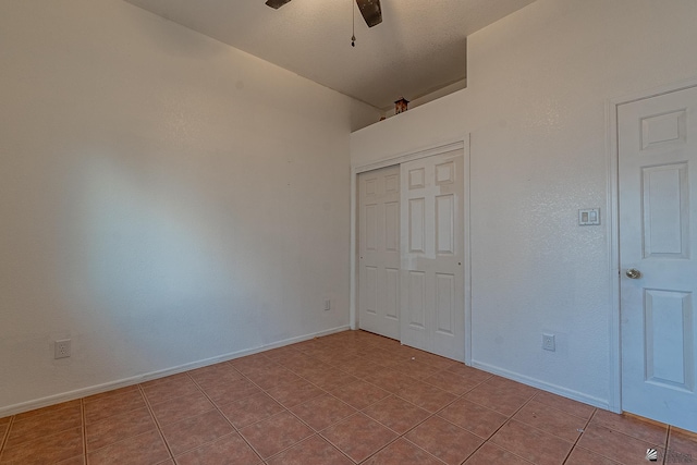 unfurnished bedroom with light tile patterned floors, a closet, and ceiling fan