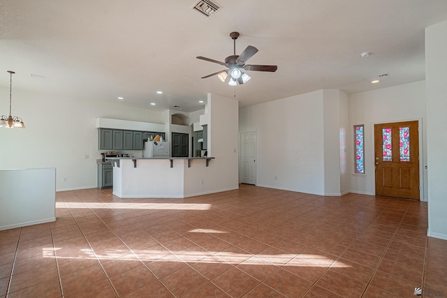 unfurnished living room with light tile patterned flooring and ceiling fan with notable chandelier