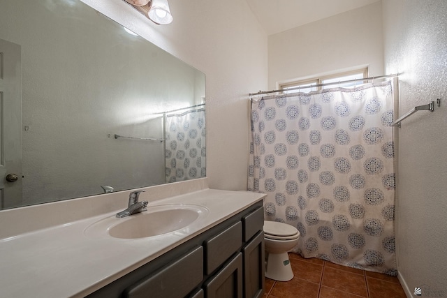 bathroom with tile patterned floors, walk in shower, vanity, and toilet