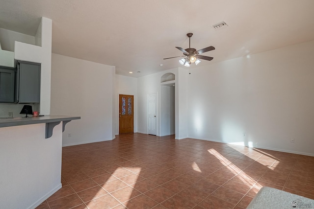 unfurnished living room featuring tile patterned flooring and ceiling fan