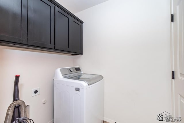 clothes washing area with washer / dryer and cabinet space