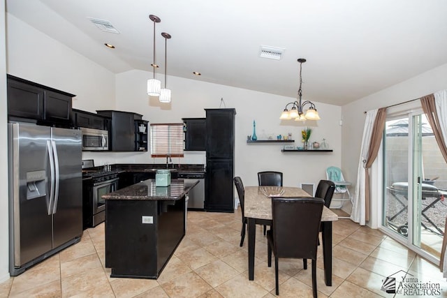 kitchen with lofted ceiling, visible vents, stainless steel appliances, and dark cabinets