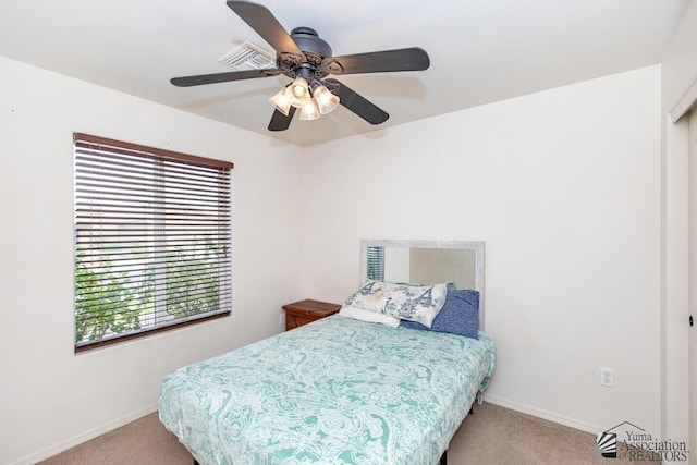 carpeted bedroom featuring ceiling fan, visible vents, and baseboards