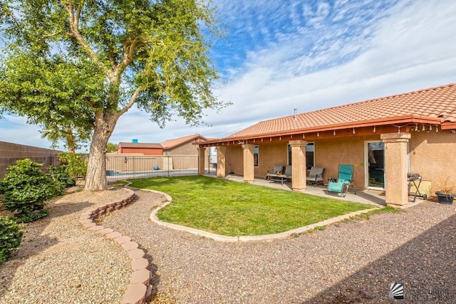 rear view of property with a patio area, a fenced backyard, a tile roof, and stucco siding