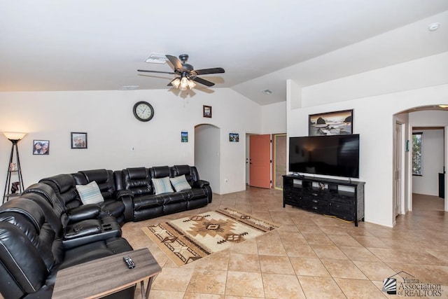 living room featuring ceiling fan, arched walkways, vaulted ceiling, and light tile patterned floors