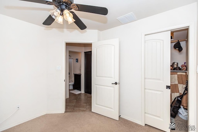 unfurnished bedroom with a closet, light colored carpet, visible vents, ceiling fan, and baseboards