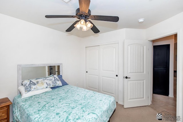 bedroom with light carpet, ceiling fan, and a closet