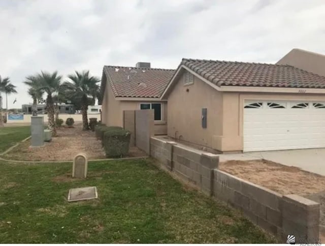 view of property exterior featuring a garage and a yard