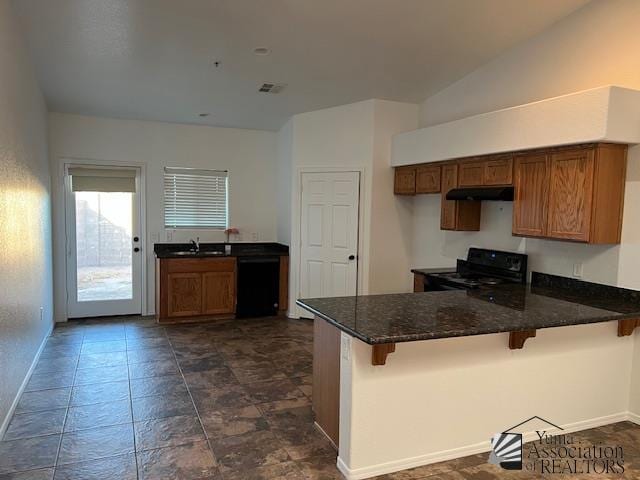 kitchen with black appliances, sink, a kitchen breakfast bar, and kitchen peninsula