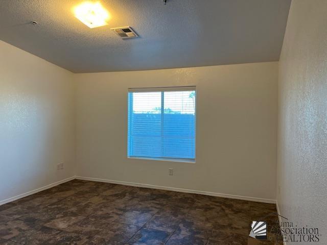 unfurnished room featuring a textured ceiling