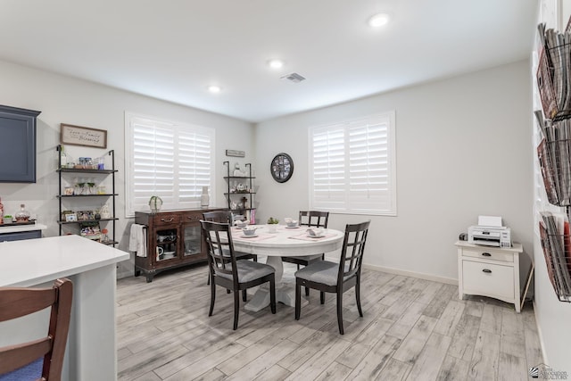 dining room featuring a healthy amount of sunlight and light hardwood / wood-style flooring