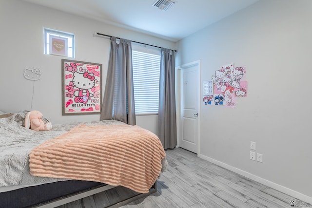 bedroom featuring multiple windows and light wood-type flooring