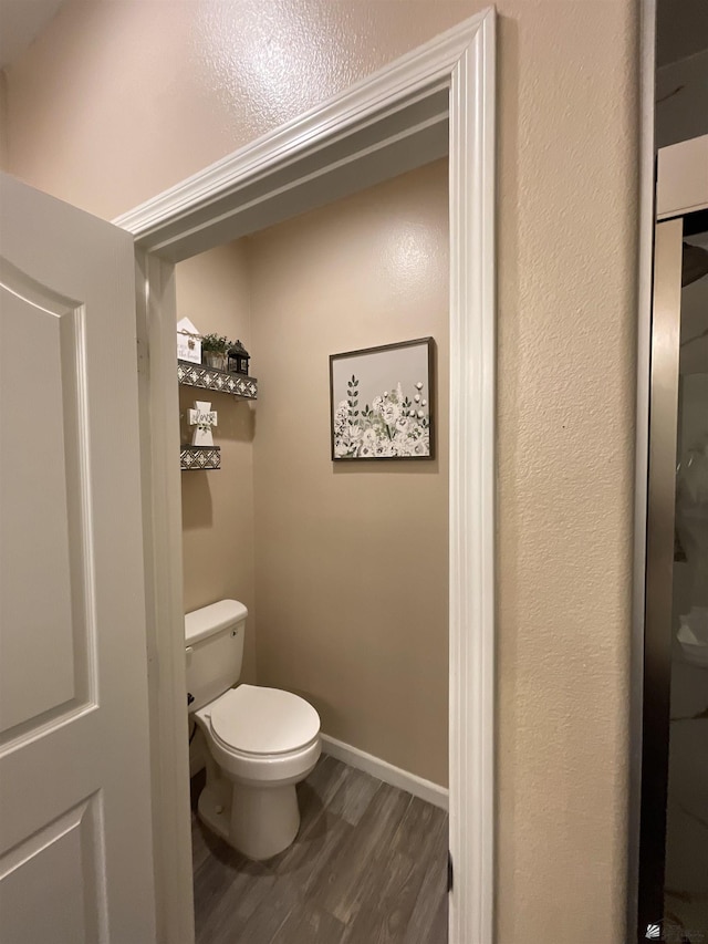 bathroom featuring hardwood / wood-style flooring and toilet