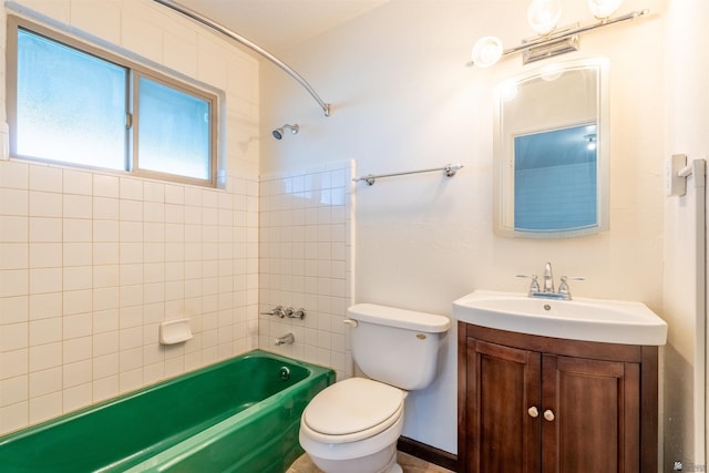 full bathroom with tiled shower / bath, vanity, and toilet