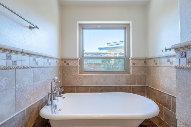 bathroom with tile walls and a tub