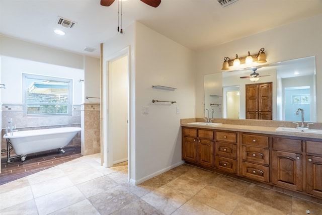 bathroom featuring vanity, ceiling fan, a tub, and tile walls