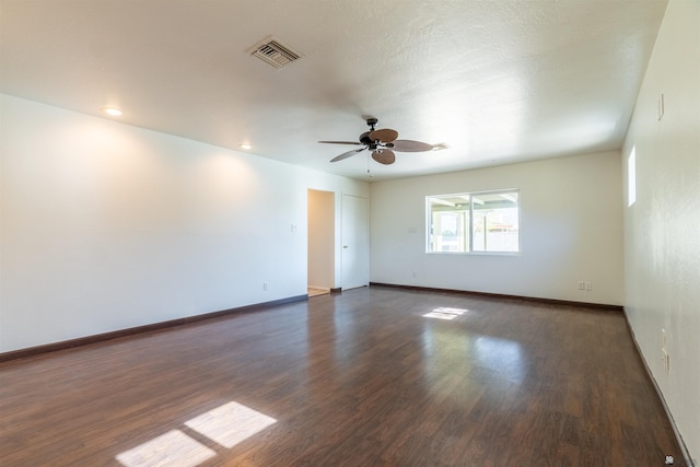 spare room featuring dark wood-type flooring and ceiling fan