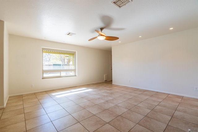 tiled spare room featuring ceiling fan