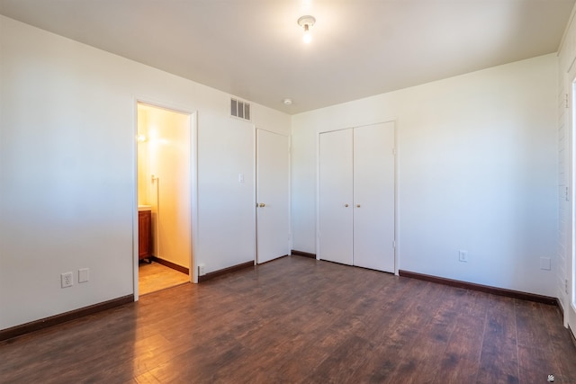 unfurnished bedroom with dark hardwood / wood-style floors, connected bathroom, and a closet