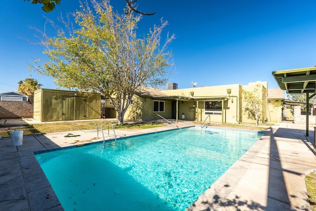 view of swimming pool featuring a patio and central air condition unit