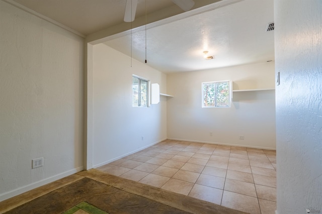 tiled empty room featuring ceiling fan