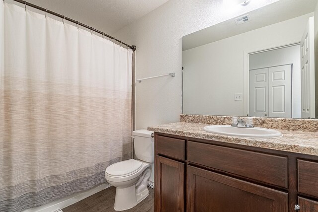 bathroom featuring a shower with curtain, hardwood / wood-style floors, vanity, and toilet