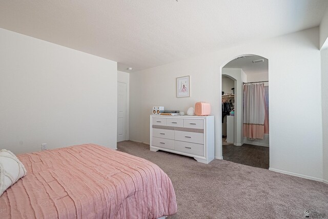 bedroom with light carpet, a closet, and a spacious closet