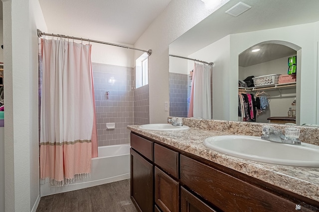 bathroom with hardwood / wood-style flooring, vanity, and shower / tub combo with curtain