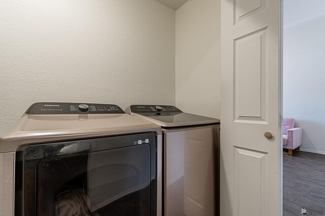 laundry room featuring hardwood / wood-style flooring and separate washer and dryer