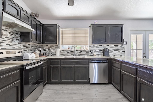 kitchen featuring stainless steel appliances, light countertops, decorative backsplash, a sink, and under cabinet range hood