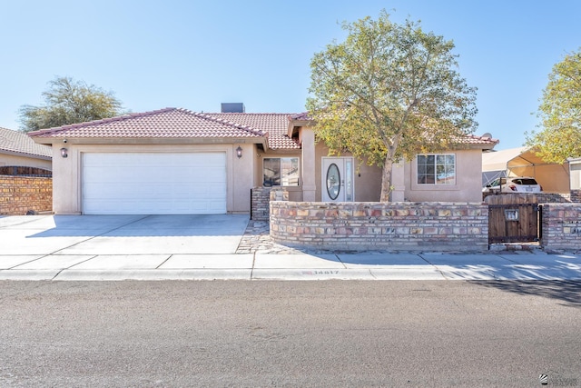 view of front of home featuring a fenced front yard, a garage, a tile roof, concrete driveway, and stucco siding