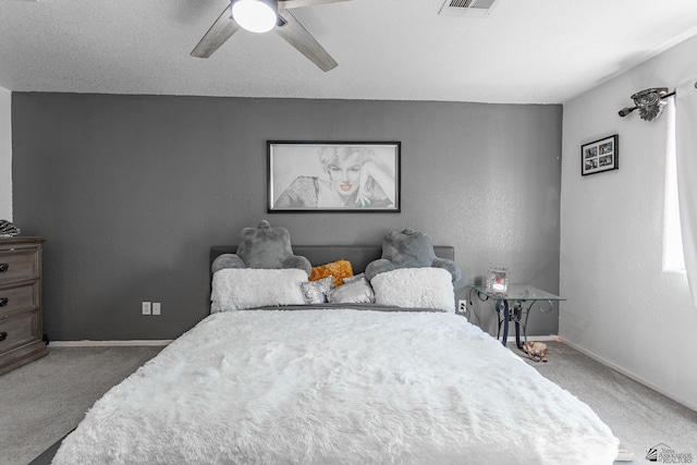 bedroom featuring a ceiling fan, visible vents, baseboards, and carpet flooring