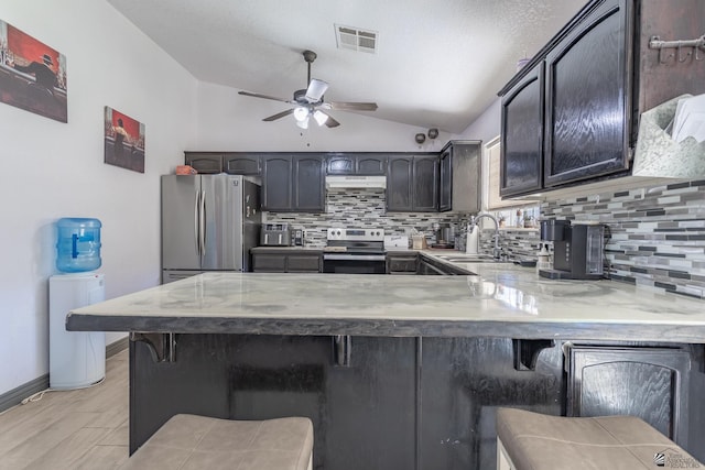 kitchen featuring visible vents, appliances with stainless steel finishes, a breakfast bar, and a sink