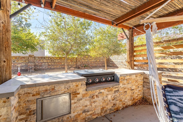 view of patio featuring fence and an outdoor kitchen