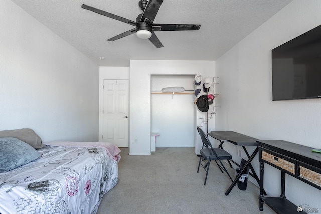 bedroom with light colored carpet, ceiling fan, and a textured ceiling