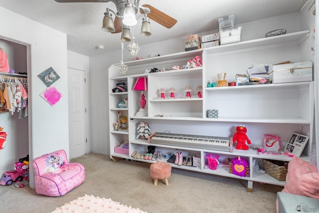 game room featuring light carpet, a textured ceiling, and a ceiling fan