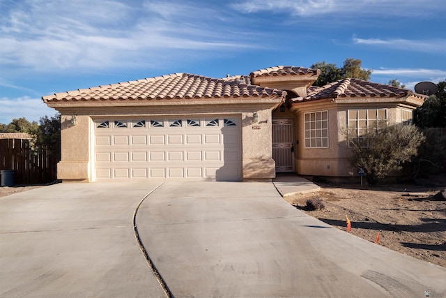 view of front of home with driveway, a tile roof, a garage, and stucco siding