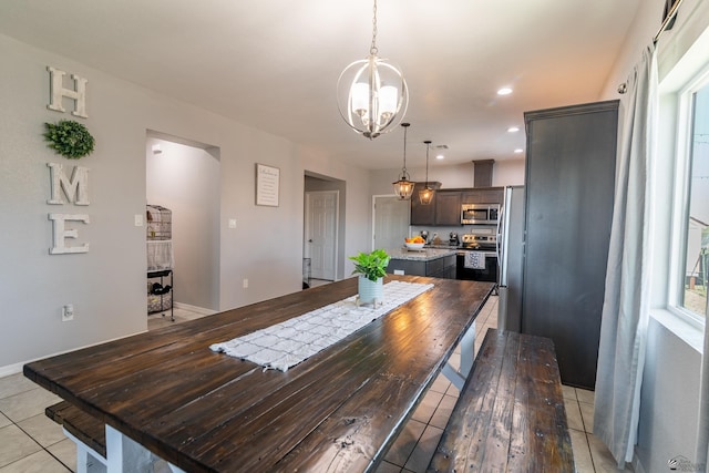 dining area featuring a chandelier and light tile patterned flooring