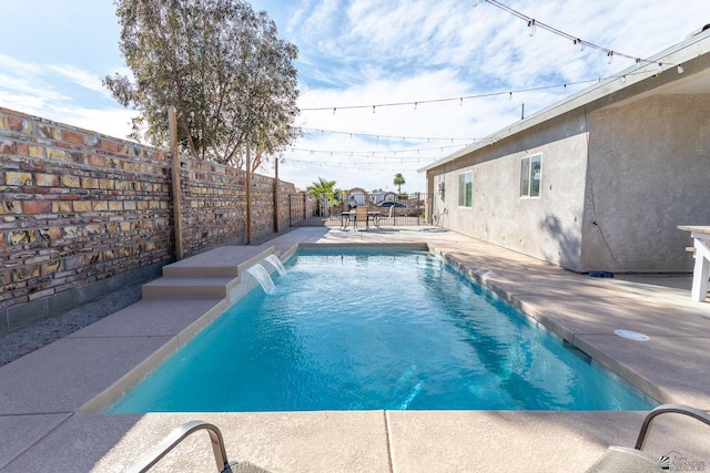 view of pool featuring pool water feature and a patio area