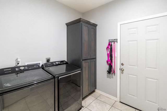 laundry area featuring cabinets, washer and clothes dryer, and light tile patterned floors