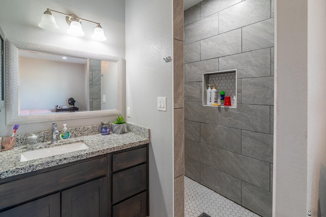 bathroom featuring vanity and tiled shower