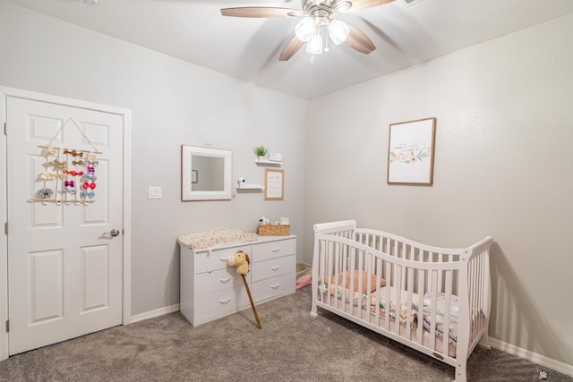 bedroom featuring a crib, ceiling fan, and carpet