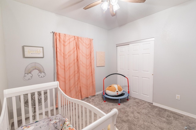 carpeted bedroom with a nursery area, ceiling fan, and a closet